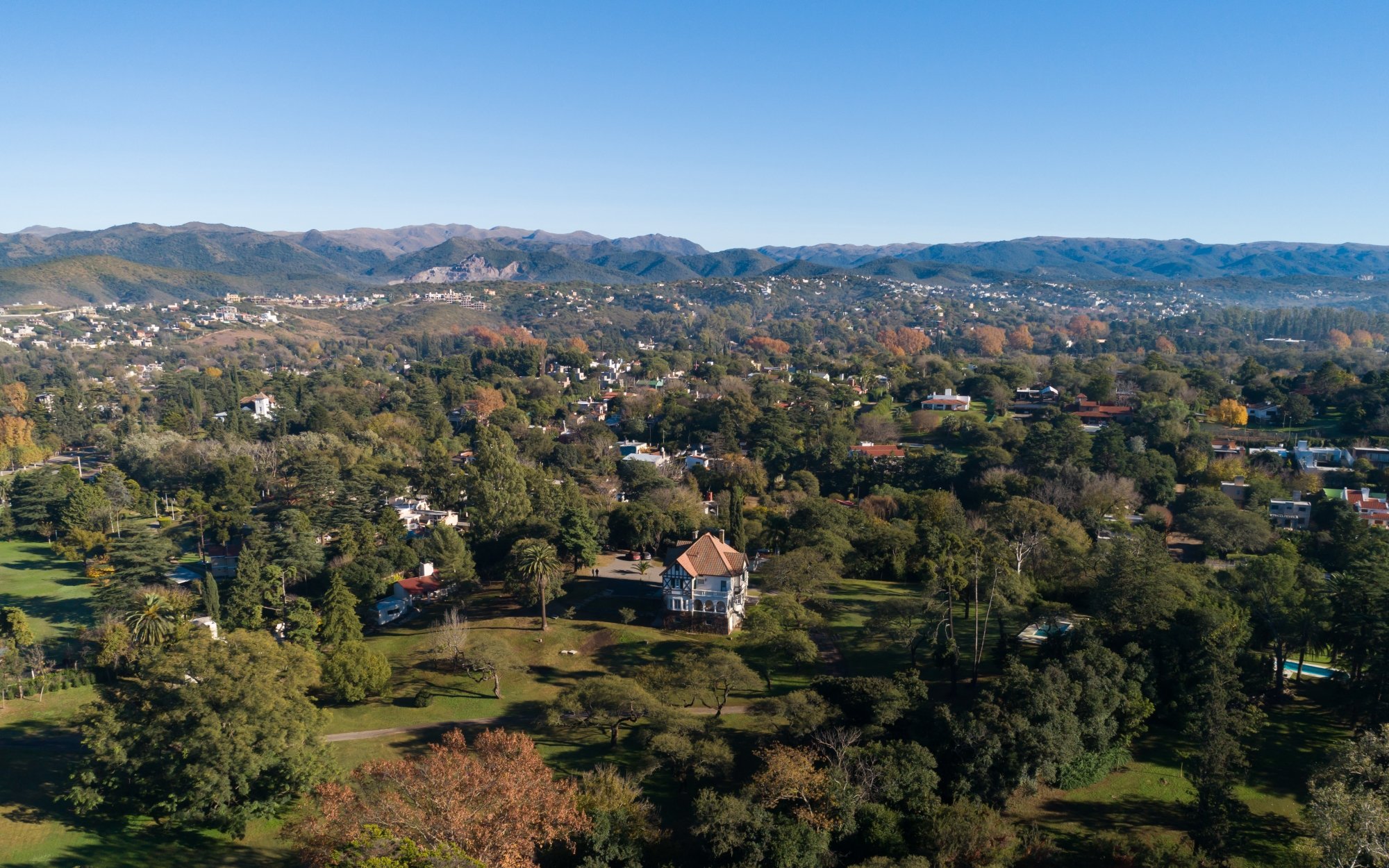 Aerial view of Attessi Lodge surrounded by mountains and forest