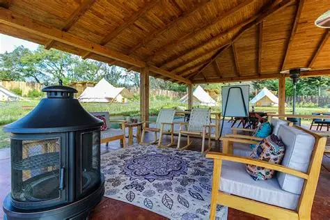 Covered pavilion with comfortable seating overlooking glamping tents
